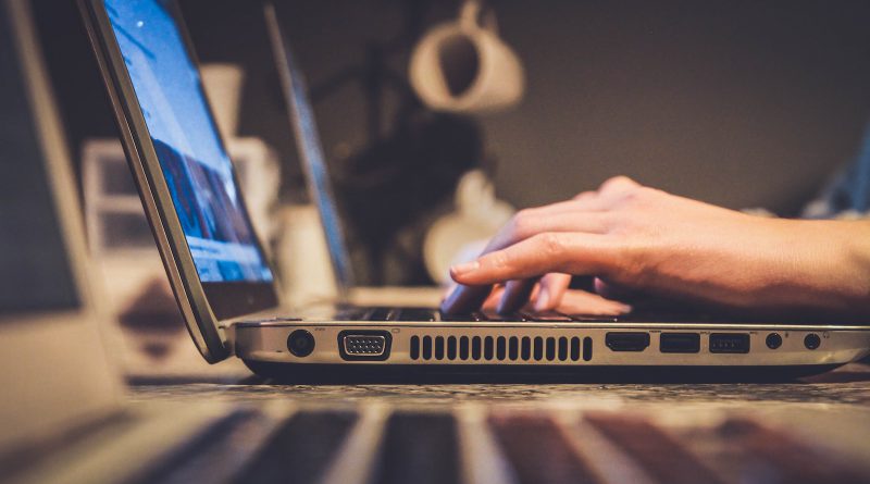 person using silver laptop computer on desk